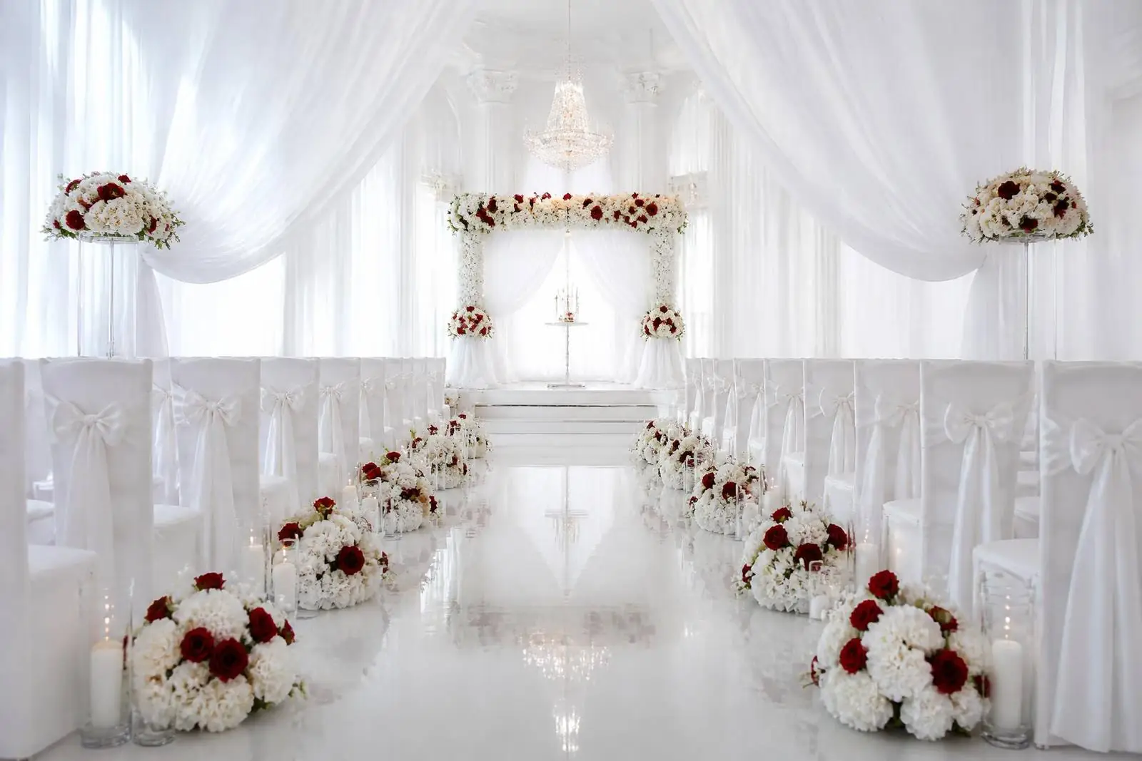 Luminous white micro-wedding ceremony styled with white roses, candlelight and sheer drapery